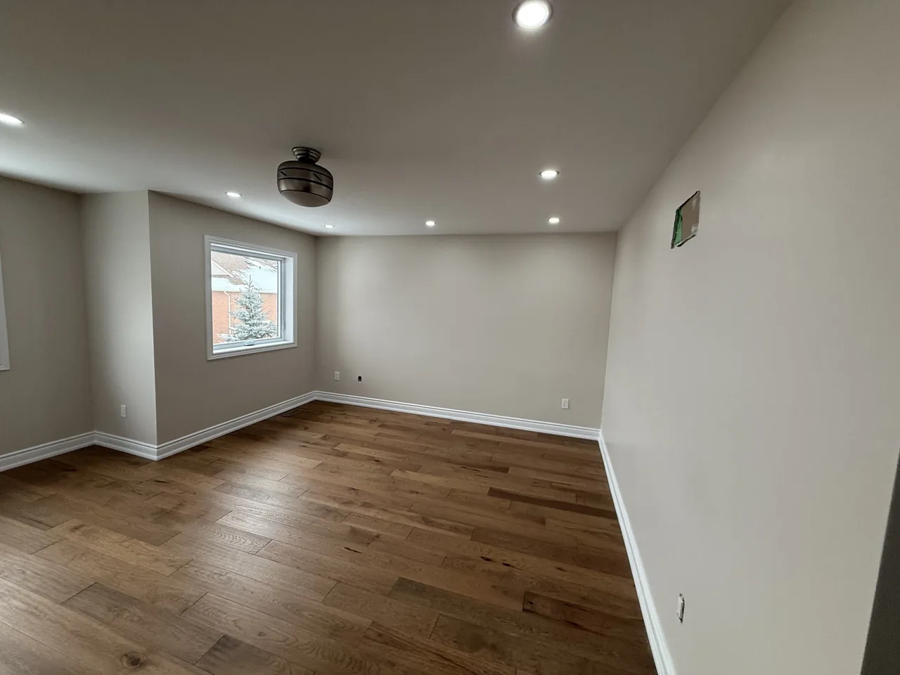 Freshly painted room with warm hardwood flooring